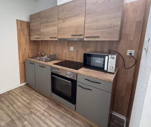 een keuken met een magnetron, een fornuis en kasten bij Apartment Pottery - Park view in Thun