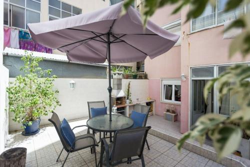a patio with a table and chairs and an umbrella at 1-Bedroom Flat with Terrace, near Metro & Arena in Lisbon
