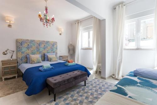 a bedroom with two beds and a chandelier at 1-Bedroom Flat with Terrace, near Metro & Arena in Lisbon