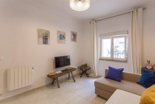 a living room with a couch and a tv at 1-Bedroom Flat with Terrace, near Metro & Arena in Lisbon