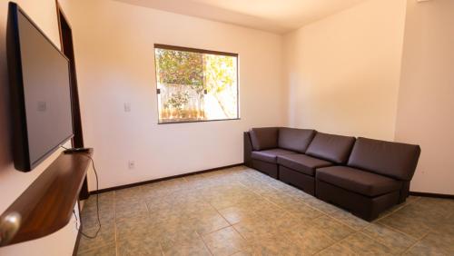 een woonkamer met een bank en een raam bij Casa com Jacuzzi, Piscina e Garagem em Jacuipe in Barra de Jacuípe