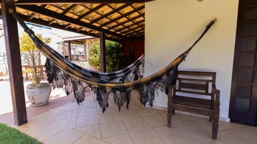 een hangmat op de veranda van een huis bij Casa com Jacuzzi, Piscina e Garagem em Jacuipe in Barra de Jacuípe