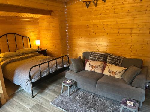 een slaapkamer met een bed en een bank in een kamer bij Glenhill Lodge in Roybridge