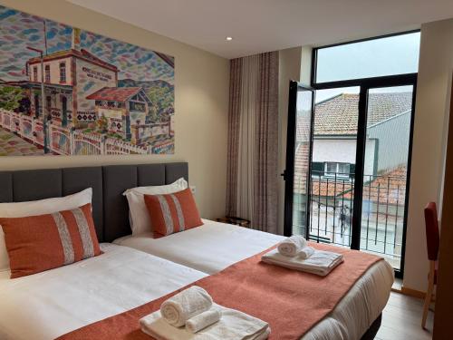 a hotel room with two beds and a large window at Oporto Station Hostel & Rooms in Porto