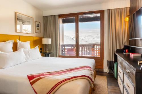 a hotel room with a bed and a window at Le Val Thorens, a Beaumier hotel in Val Thorens