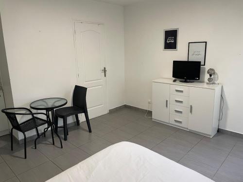 un soggiorno con tavolo, sedie e TV di Studio Vinci 2 a Calais