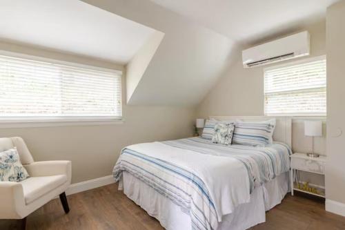 a white bedroom with a bed and a chair at Boat House in Downingtown