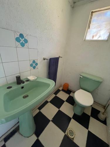 a bathroom with a green sink and a toilet at Casa Mirador Pichilemu in Pichilemu