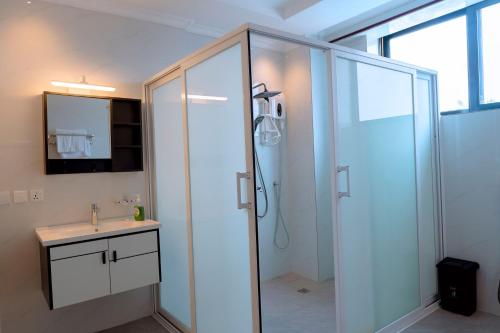 a bathroom with a shower and a sink at Dorlan Hotel in Kigali