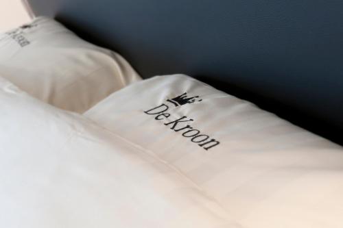 a white pillow with the word bedroom written on it at Feestzaal De Kroon in Diksmuide