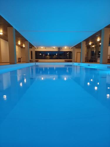 an empty swimming pool at night with a blue light at TOP Appartamenti in Passo del Tonale