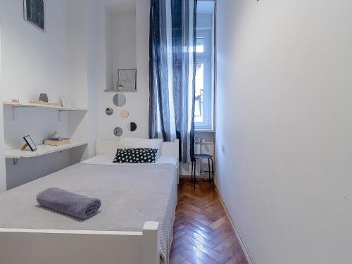 een kleine kamer met twee bedden en een raam bij Apartment G37 in Zagreb