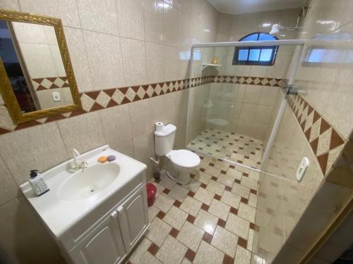 a bathroom with a shower and a sink and a toilet at Espaço Sol in Peruíbe