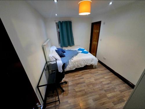 een slaapkamer met een bed met blauwe kussens erop bij Stratford Guest House in Londen