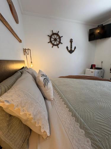 una camera con un letto e un cartello nautico sul muro di Suíte Boqueirão Tati Ortega a Ilha Comprida