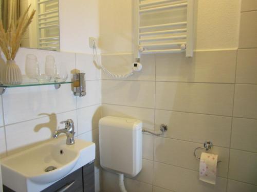 ein Badezimmer mit Toilette, Waschbecken und Spiegel in der Unterkunft Stadtzentrum , nähe Schloss in Klütz