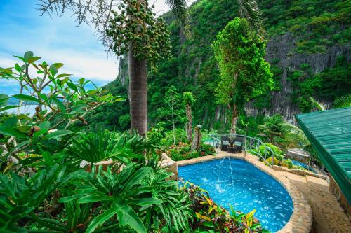 een zwembad in een tuin met een berg bij El Nido Viewdeck Cottages in El Nido