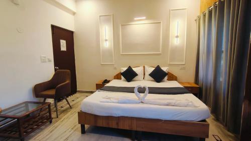 a hotel room with a bed and a chair at Hotel Laxmi Palace Near ISBT Dehradun in Dehradun