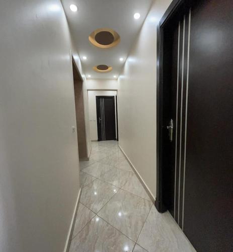 a hallway with a door and a tile floor at Egypt Love in Al Badrashayn