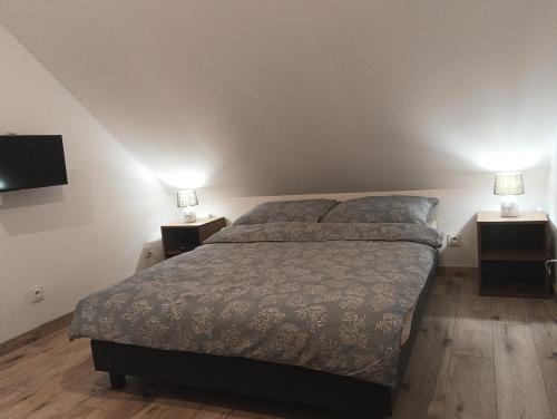 une chambre avec un lit et deux tables de nuit avec lampes dans l'établissement Letnisko, à Lubawka