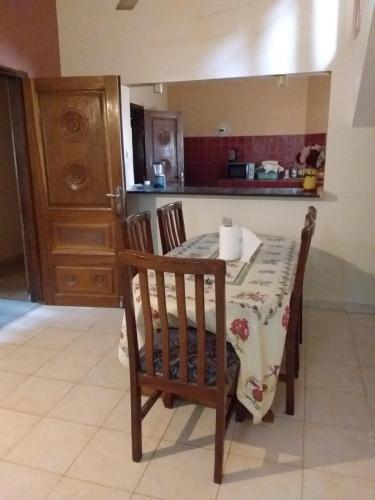 een keuken met een tafel, 2 stoelen en een aanrecht bij Résidence Diamane Sokone in Sokone