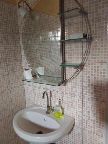 een badkamer met een wastafel en een spiegel bij Résidence Diamane Sokone in Sokone