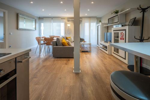 une cuisine et un salon avec un canapé et une table dans l'établissement Apartamento Luis de Vargas, à Huelva