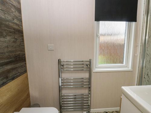 a bathroom with a toilet and a window at The Family Pod - Gower in Swansea