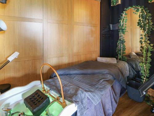 a room with a bed and a bath tub at The Family Pod - Gower in Swansea