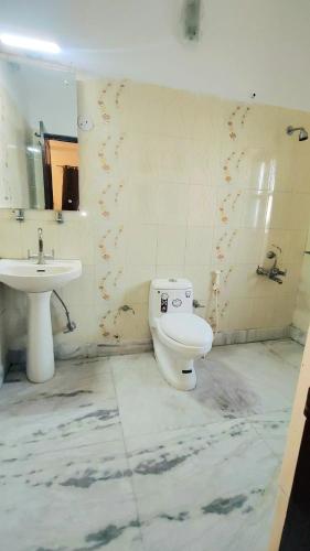 a bathroom with a toilet and a sink at Hotel Laxmi Palace Near ISBT Dehradun in Dehradun