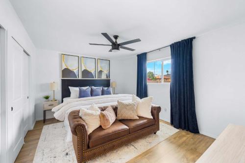 a bedroom with a couch and a bed with blue curtains at Private Pool Haven Backyard & Putting Green in Phoenix