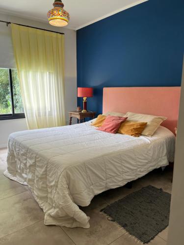 een slaapkamer met een groot bed met een blauwe muur bij Casa La Azulita in Lobos