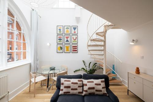 a living room with a staircase and a couch at The Regency by Nestor in London