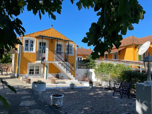 a yellow house with a staircase in a yard at Campos Essencia in Arganil