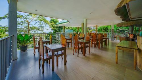 a dining room with tables and chairs on a balcony at El Nido Viewdeck Cottages in El Nido