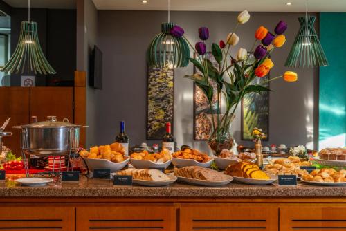 un buffet con molti tipi diversi di cibo su un bancone di Hotel Laghetto Viale a Gramado