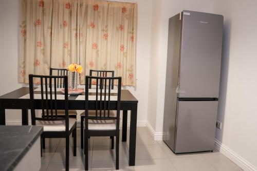a black dining room table with chairs and a refrigerator at Oxford sweet home in Oxford