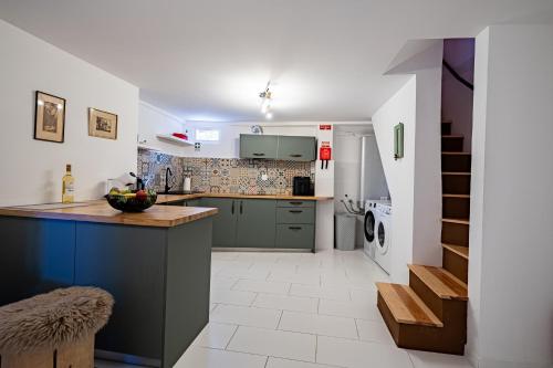 a kitchen with green cabinets and a white tile floor at Picturesque stay Porto da Cruz in Porto da Cruz