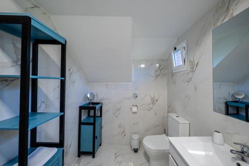 a white bathroom with a toilet and a sink at Picturesque stay Porto da Cruz in Porto da Cruz