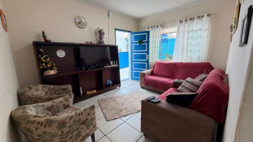 ein Wohnzimmer mit Sofa und Fernseher in der Unterkunft Casa Pet Friendly c 3 Quartos e Garagem no Jardim in Poços de Caldas