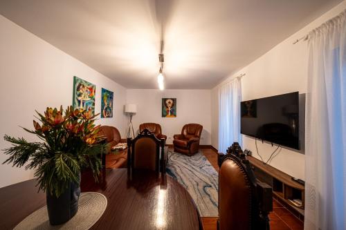a living room with a table and a tv at Picturesque stay Porto da Cruz in Porto da Cruz