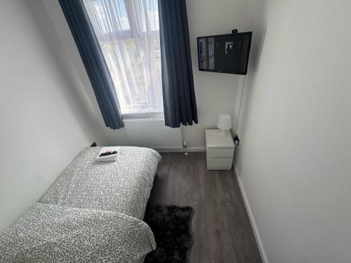 un salon avec un canapé et une fenêtre dans l'établissement BXH B4 Cozy single room Bexleyheath, à Bexleyheath