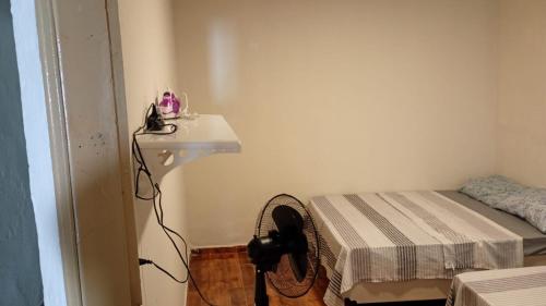 ein Zimmer mit Ventilator, Waschbecken und Bett in der Unterkunft Casa a 1 Minuto da basilica in Aparecida