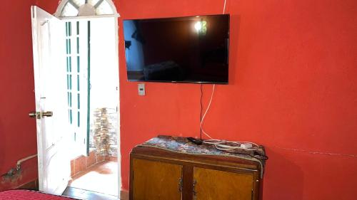 een rode kamer met een tv aan een rode muur bij Casa María Victoria 