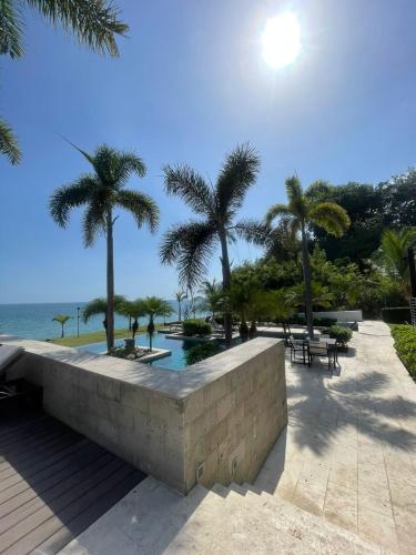 a resort with palm trees and a swimming pool at Ideal home to relax and enjoy with family in El Nance