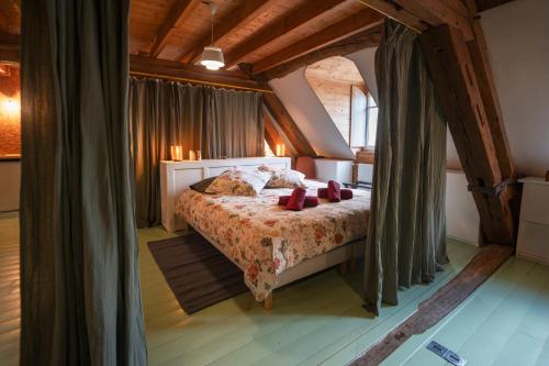 a bedroom with a bed with red pillows on it at Gîte insolite in Nuits-Saint-Georges