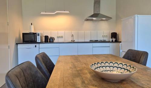 a kitchen with a table with chairs and a bowl on it at Guesthouse Bij de Groenestraat in Nijmegen