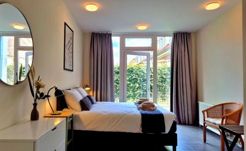 a bedroom with a bed and a large window at Guesthouse Bij de Groenestraat in Nijmegen