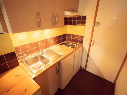 een kleine keuken met een spoelbak en een aanrecht bij Studio divisible, balcon, animaux acceptés, casier à skis, linge de lit inclus - FR-1-291-839 in Valmorel