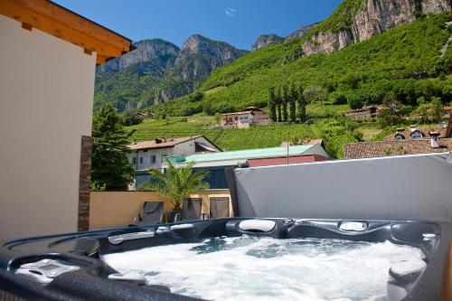 a hot tub on a balcony with a view of mountains at Gasthof Hotel Terzer in Cortaccia